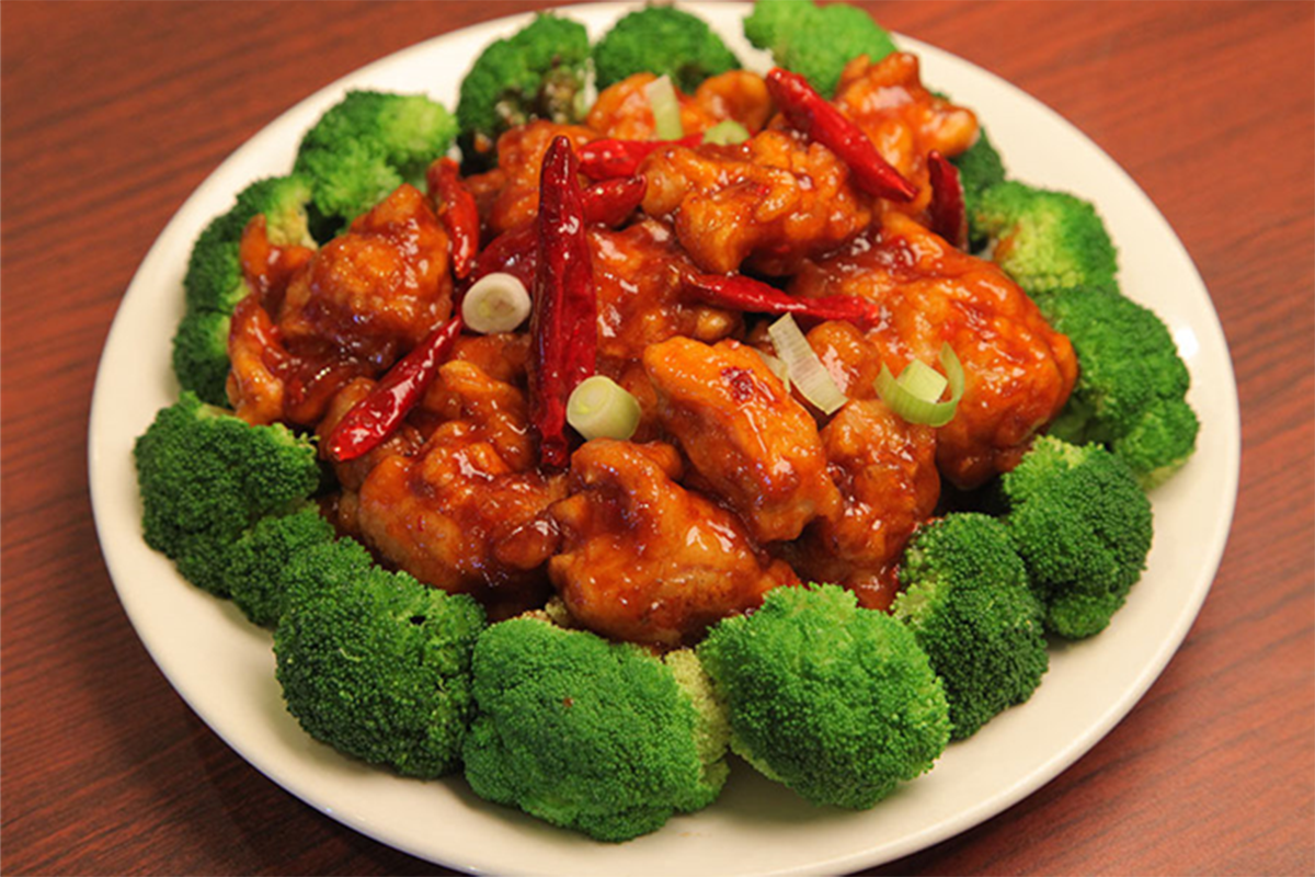 Glazed chicken with dried red chilies and scallions, surrounded by fresh broccoli