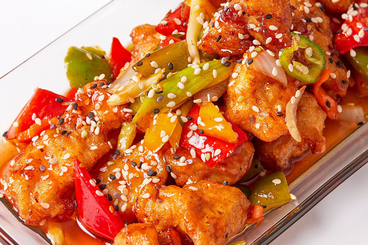 Saucy chicken with red, green, and yellow peppers, onions, and sesame seeds